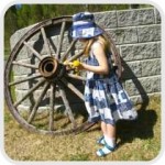 girl looking at a wagon wheel